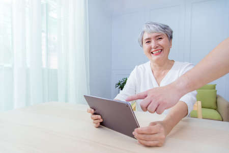 Senior Asia woman is working from home, using laptop and smart phone.の写真素材
