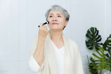 Asian senior woman suffer from cough with face mask protectionの写真素材