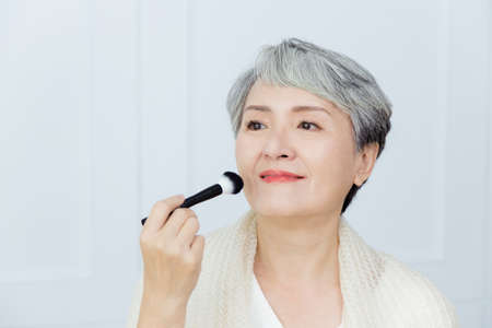 Asian senior woman suffer from cough with face mask protectionの写真素材