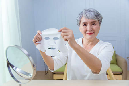 Asian senior woman suffer from cough with face mask protectionの写真素材