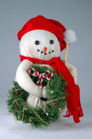 Old Christmas snowman with wreath and candy cane.の写真素材