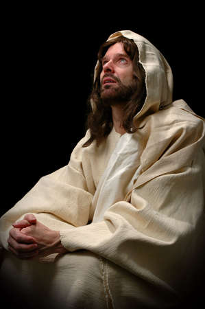 Jesus in prayer over a dark backgroundの写真素材