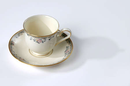 Tea cup and soucer with flower patterns over a neutral background.の写真素材
