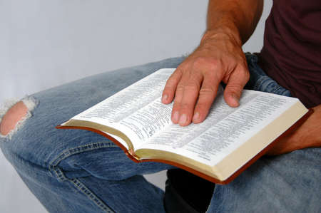 Bible on man's lap with hands
