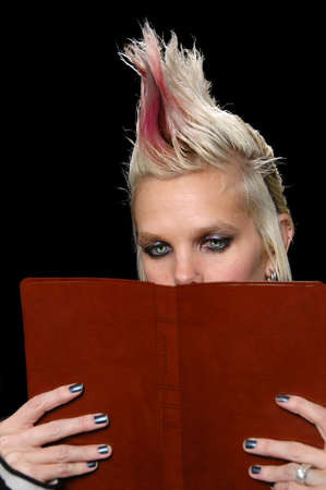 Punk Girl with beautiful eyes Reading Bible isolated over a black background.の写真素材