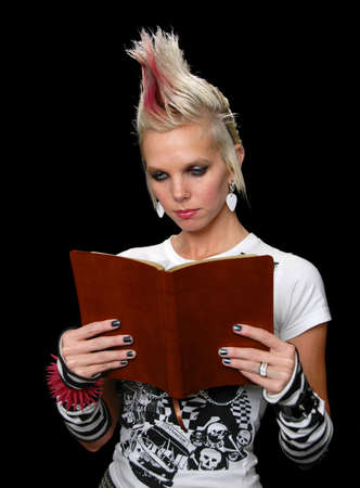 Punk Girl Reading Bible isolated over a black backgroundの写真素材
