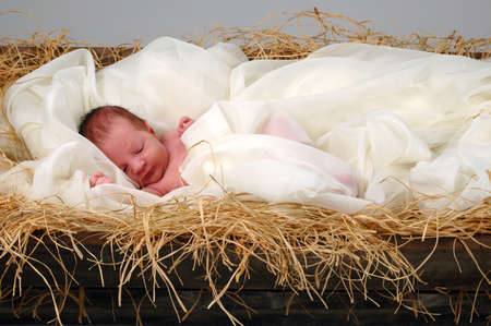 The Christmas story with baby Jesus sleeping in mangerの写真素材