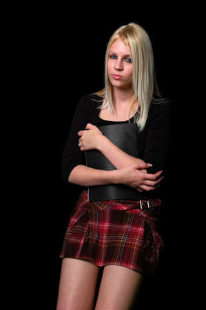 Young woman standing holding a file isolated over a black background.の写真素材