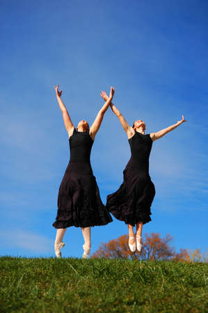 Ballerinas jumping during performance outdoors.の写真素材