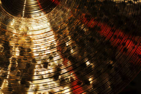 Detail of brass cymbal with red light reflectionsの写真素材