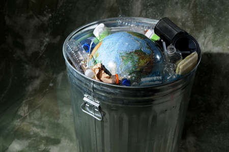 Earth in a trash can with plastics and rubbishの写真素材