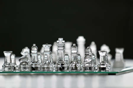 Glass chess pieces on boardの写真素材