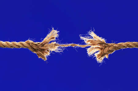 Rope breaking isolated over a blue backgroundの写真素材