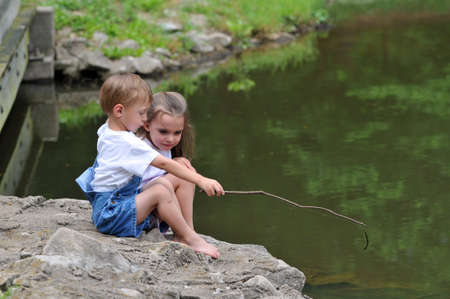 Children fishing with improvised fishing poleの写真素材
