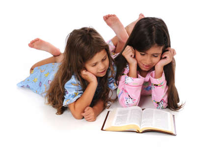 Young girls in pajamas reading the Bible before bedtimeの写真素材