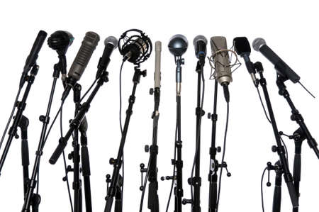 Microphones aligned together isolated over a white backgroundの写真素材