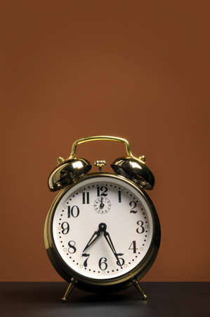 Alarm clock with space for text over a brown backgroundの写真素材