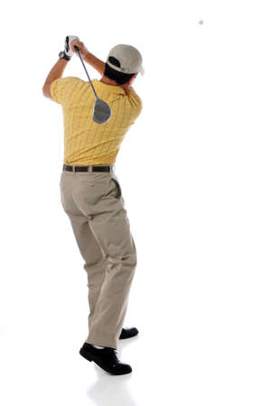 Golfer watching ball after swingingの写真素材