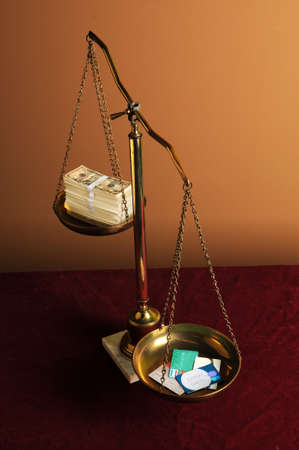 Credit card deft concept with scales holding credit cards and cashの写真素材