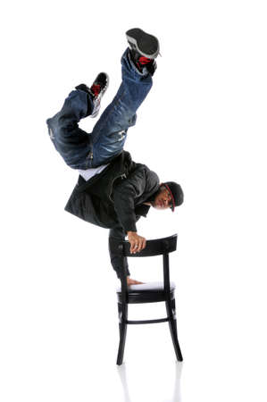 Hip hop man performing dance standing on chair