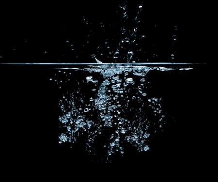 Water splashing forming air bubbles over a black backgroundの写真素材