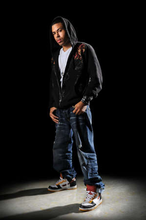 African American hip hop dancer standing over a dark background