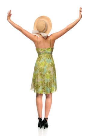 Beautiful woman dressed in summer dress and hat with arms raisedの写真素材