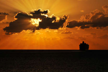 Cruise ship sailing into the sunset with sunburst effectの写真素材