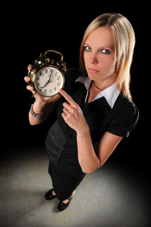 Attractive businesswoman pointing at alarm clockの写真素材