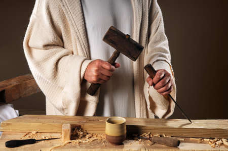 Jesus hands with wooden mallet and chiselの写真素材