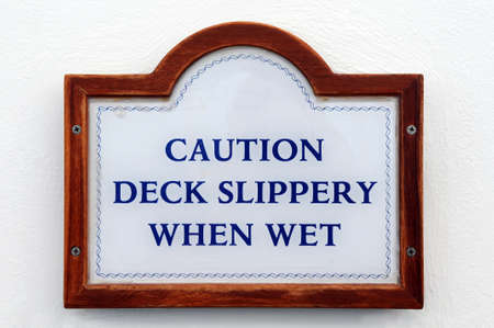 Caution Deck Spippery When Wet sign on a white wallの写真素材