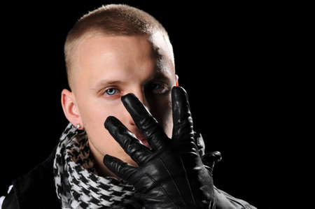 Portrait of hip hop man with gloved hand in front of faceの写真素材