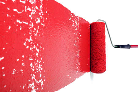 Pain roller with red paint on white wallの写真素材