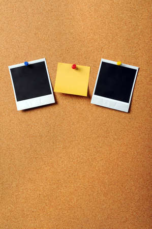 Adhesive note pad with vintage photographs pinned to cork board with copyspaceの写真素材