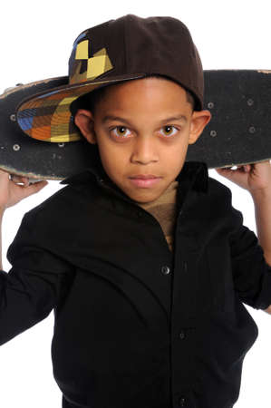 Portrait of young African American boy with skateboard behind headの写真素材