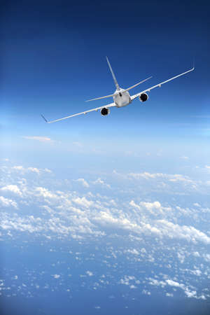 Jet airliner in flight with clouds in the distance