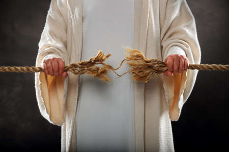 Jesus hands holding frayed rope over dark background