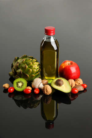 Fresh fruits and vegetables and olive oil on reflective table