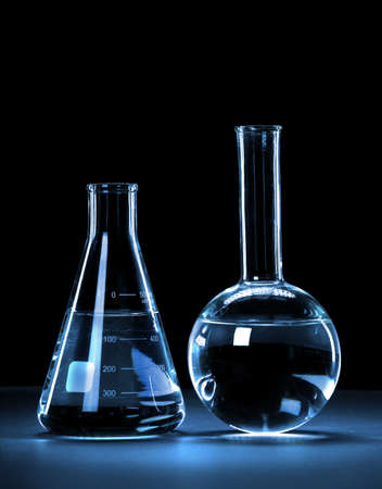 Laboratory glassware with blue light over dark background