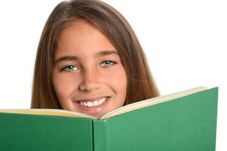 Young girl behind hardcover book isolated over white backgroundの写真素材