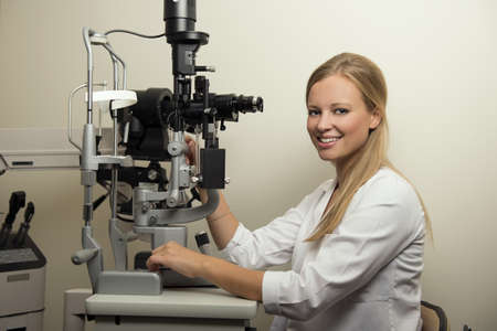Portrait of beautiful female eye doctor in examination room