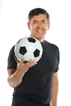 Portrait of mature Hispanic man holding soccer ball isolated over white backgroundの写真素材