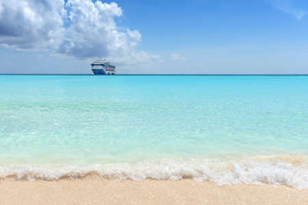 Caribbean beach with passenger cruise ship in backgroundの写真素材