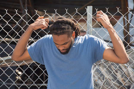 FERGUSON, MO/USA â AUGUST 15, 2015: Man at the Site of Quick Trip holds onto fence after Police Chief Thomas Jackson release of the name of the officer that shot Michael Brown.のeditorial素材