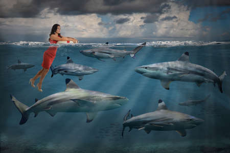 Competitive business concept with businesswoman swimming with sharksの写真素材