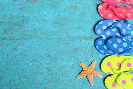 Multicolored sandals and starfish on painted wood planksの写真素材
