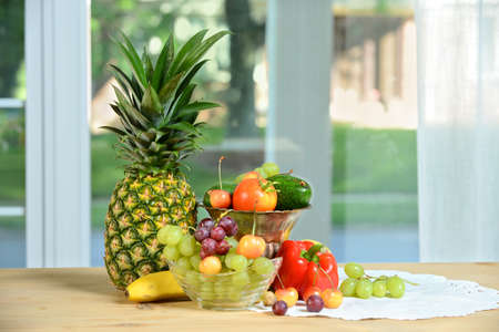 Various fruits and vegetables on table near windowの写真素材