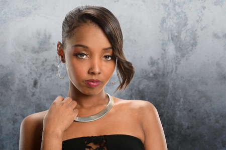 Portrait of young African American woman over gray background