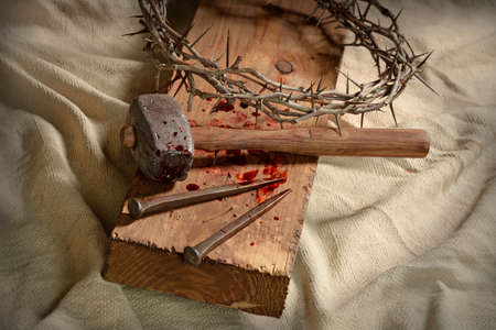 Crown of thorns, nails and hammer on wooden crossの写真素材