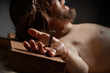 Jesus  on the cross with nail and hand in foregroundの写真素材